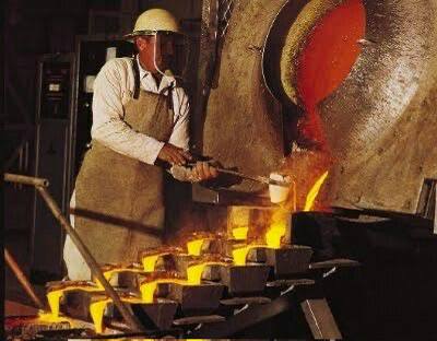 Refinery operator pouring molten gold into bar molds